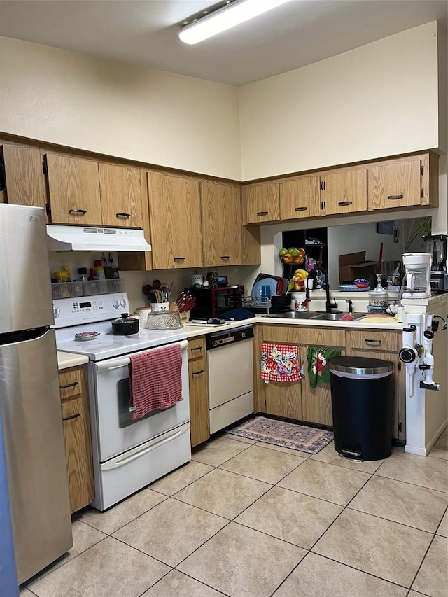 kitchen featuring sink, white appliances, light tile patterned floors, and a towering ceiling