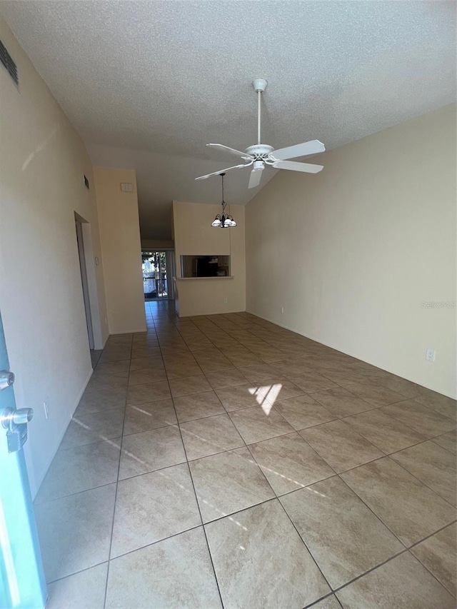 unfurnished living room with lofted ceiling, light tile patterned floors, a textured ceiling, and ceiling fan