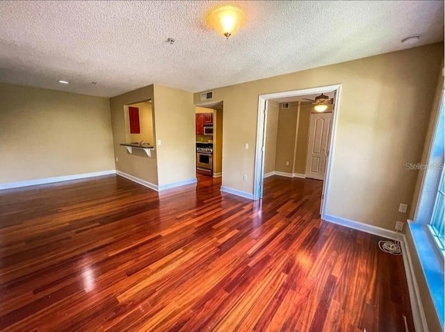 empty room with dark wood-type flooring and a textured ceiling