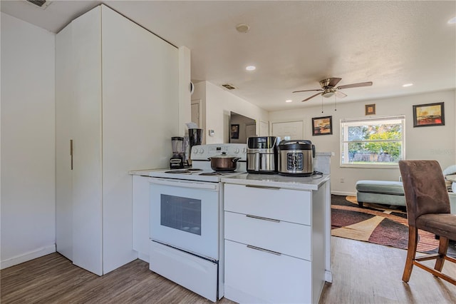 kitchen with white cabinetry, white electric range oven, ceiling fan, and light hardwood / wood-style flooring