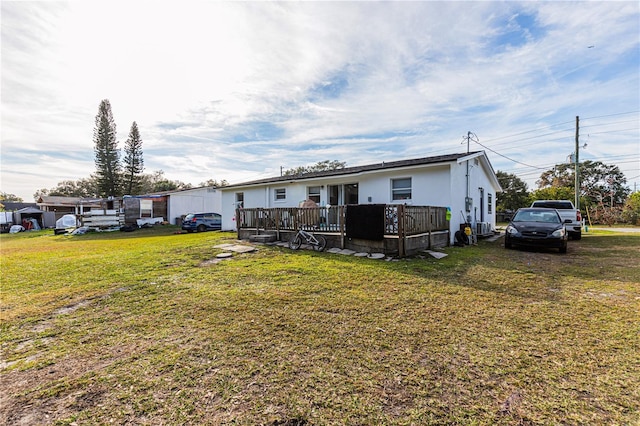 view of front of house featuring a wooden deck and a front lawn