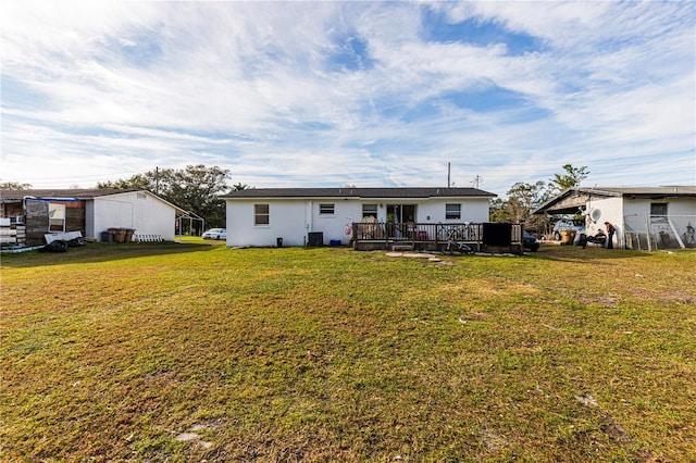 back of property with a wooden deck and a lawn