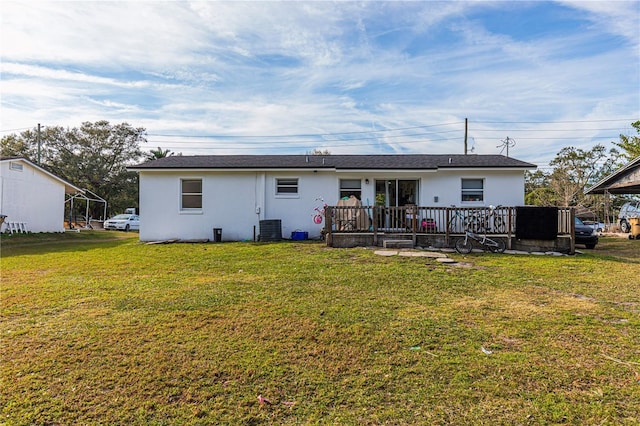 back of property featuring a wooden deck, central AC, and a lawn