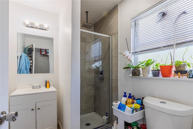 bathroom with vanity, toilet, and an enclosed shower