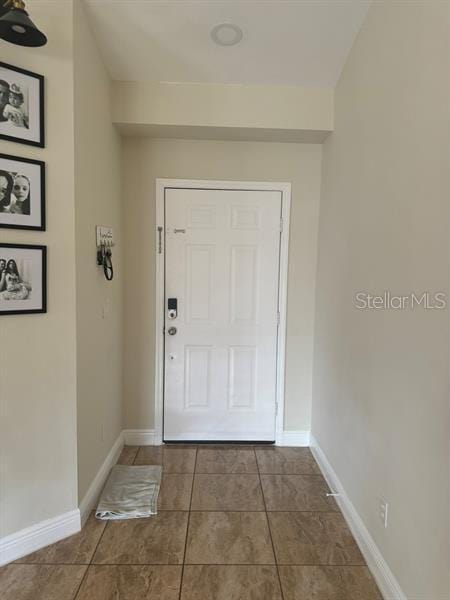 doorway to outside with tile patterned flooring