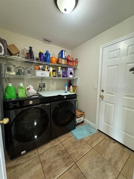 clothes washing area with separate washer and dryer and light tile patterned floors