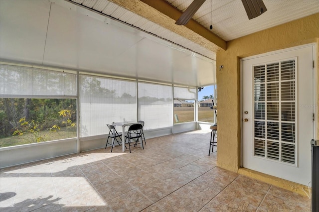 unfurnished sunroom featuring ceiling fan