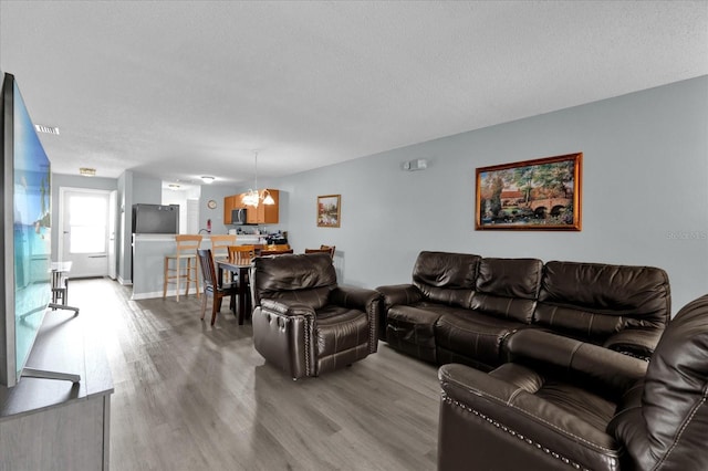 living room with light hardwood / wood-style floors and a textured ceiling