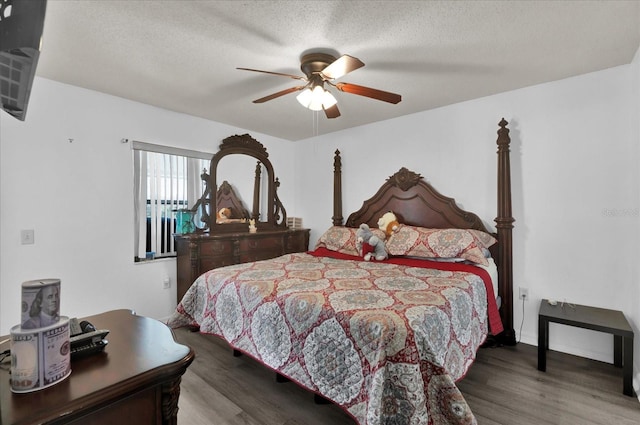 bedroom featuring ceiling fan, wood-type flooring, and a textured ceiling