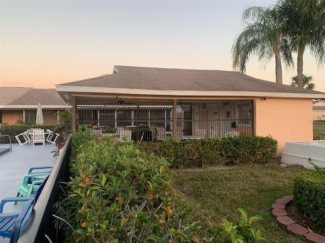 back house at dusk with a patio area