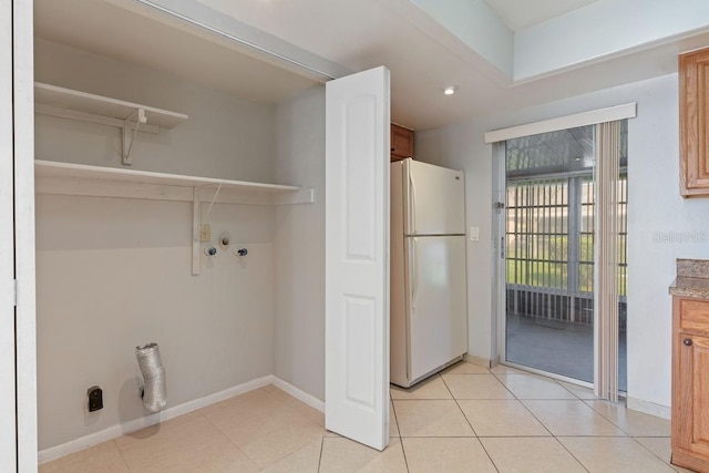 clothes washing area featuring light tile patterned flooring, laundry area, baseboards, and washer hookup