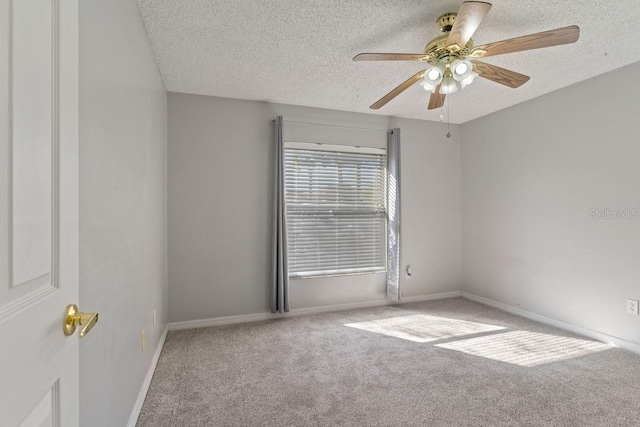 empty room featuring ceiling fan, carpet, baseboards, and a textured ceiling