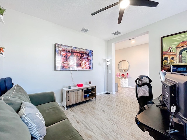 office featuring ceiling fan, a textured ceiling, and light wood-type flooring