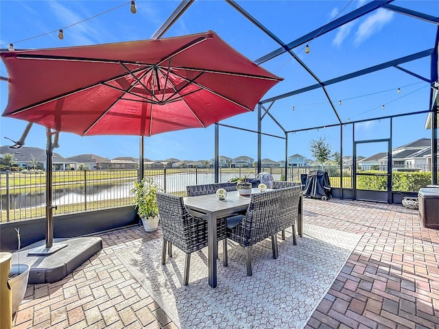 view of patio / terrace featuring a water view and a lanai