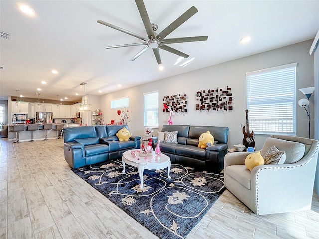 living room with light hardwood / wood-style floors and ceiling fan