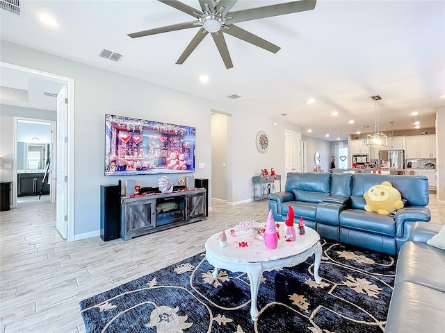 living room featuring light hardwood / wood-style flooring and ceiling fan