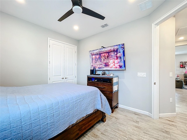 bedroom featuring ceiling fan, light hardwood / wood-style floors, and a closet