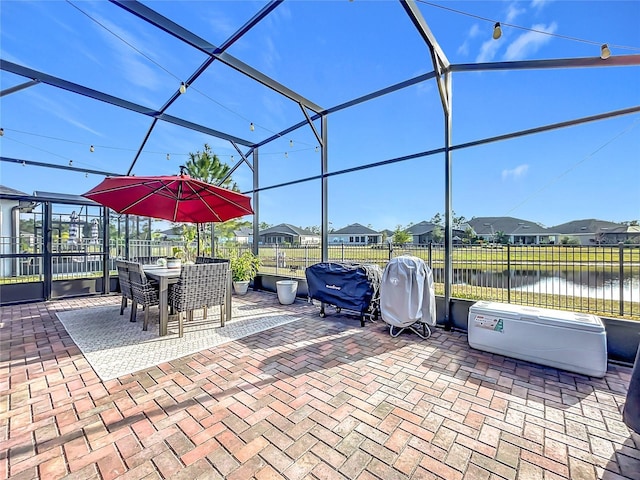 view of patio / terrace featuring a water view and a lanai