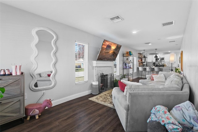 living room featuring dark wood-type flooring and a fireplace