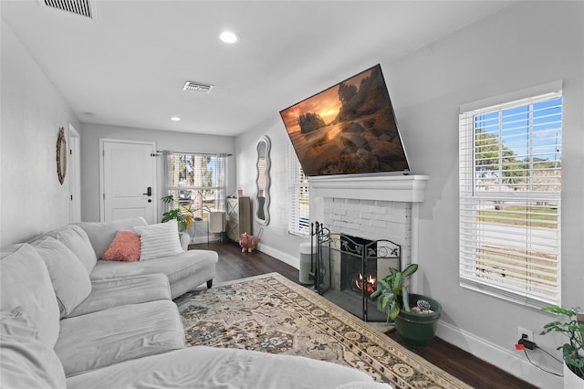 living room with dark wood-type flooring and a fireplace