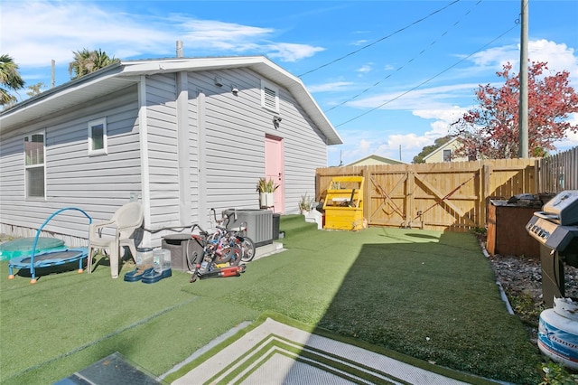 view of property exterior with a trampoline and a yard