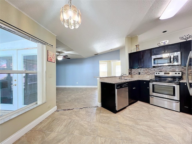 kitchen with sink, hanging light fixtures, kitchen peninsula, stainless steel appliances, and backsplash