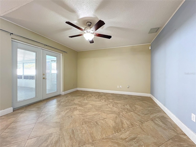 spare room featuring ceiling fan, french doors, and a textured ceiling