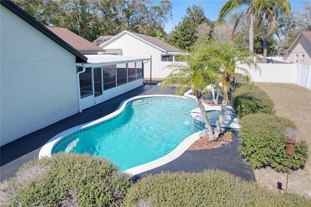 view of pool with a sunroom and pool water feature