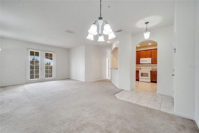 interior space with light carpet, a notable chandelier, and french doors