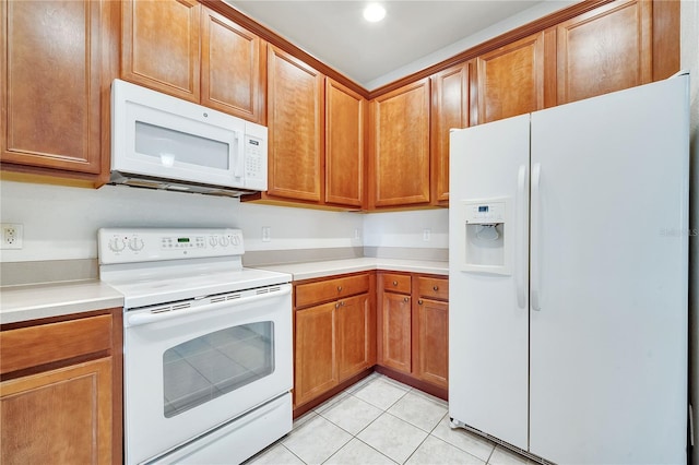 kitchen featuring light tile patterned floors and white appliances