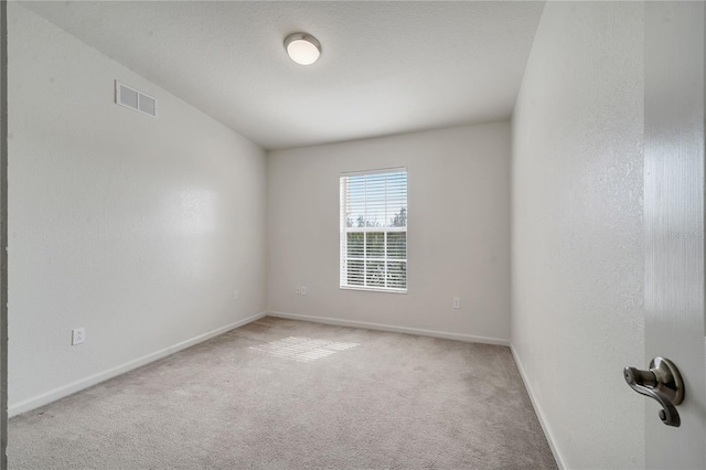 carpeted spare room featuring a textured ceiling