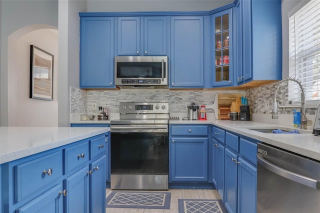 kitchen featuring sink, stainless steel appliances, and blue cabinets