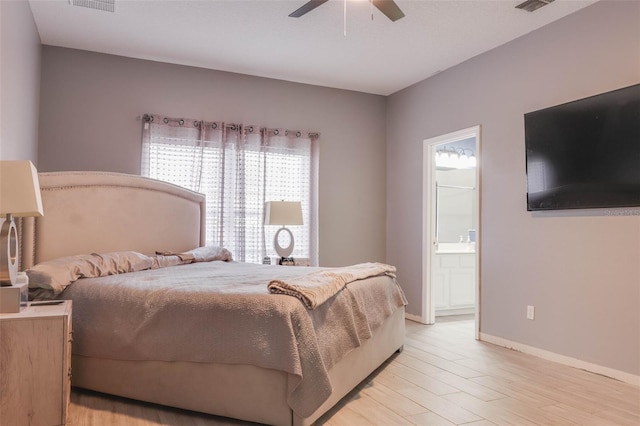 bedroom with ceiling fan, ensuite bath, and light hardwood / wood-style flooring