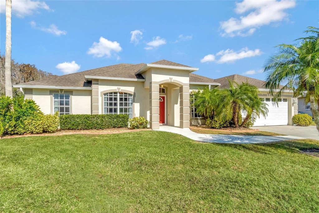 view of front of home with a garage and a front lawn