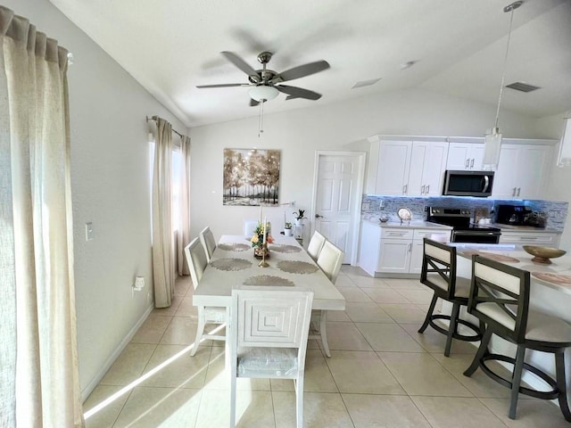 dining room with light tile patterned flooring, lofted ceiling, and ceiling fan