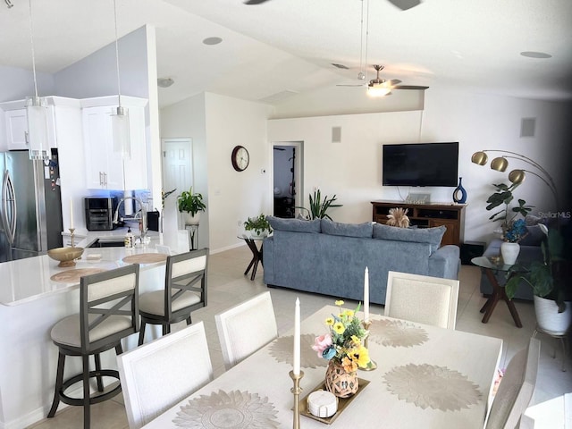 tiled dining area with sink, vaulted ceiling, and ceiling fan