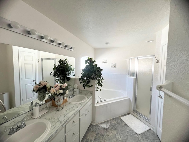 bathroom featuring vanity, shower with separate bathtub, and a textured ceiling