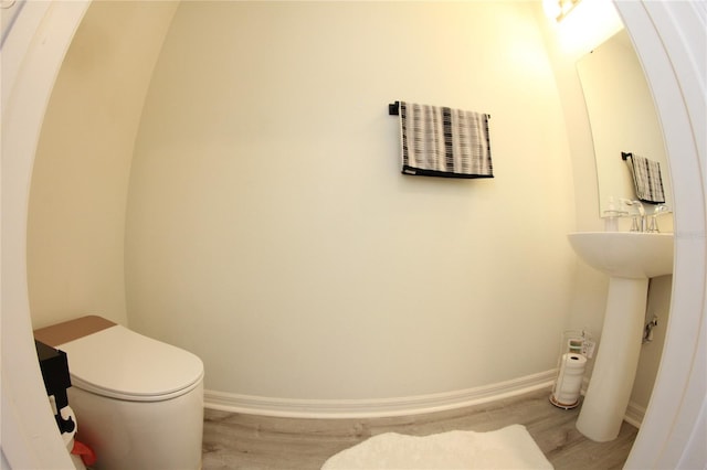 bathroom with wood-type flooring and toilet