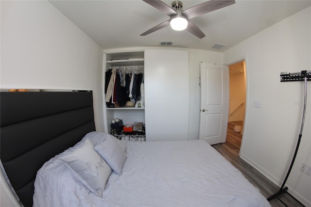 bedroom featuring dark hardwood / wood-style floors, a textured ceiling, ceiling fan, and a closet