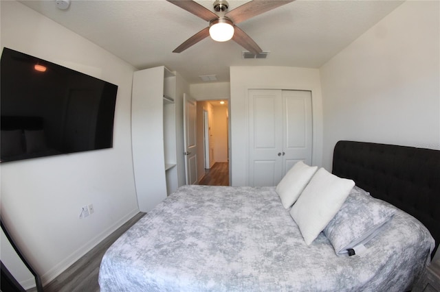 bedroom with ceiling fan, dark hardwood / wood-style flooring, and a closet