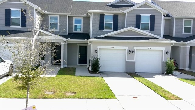 multi unit property featuring a garage and a front yard