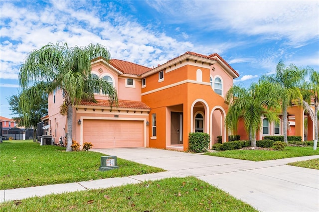 mediterranean / spanish-style house featuring a garage, a front yard, and central air condition unit