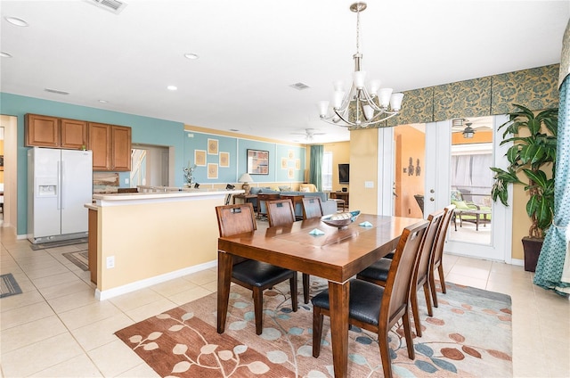 dining area with a wealth of natural light, ceiling fan with notable chandelier, and light tile patterned floors