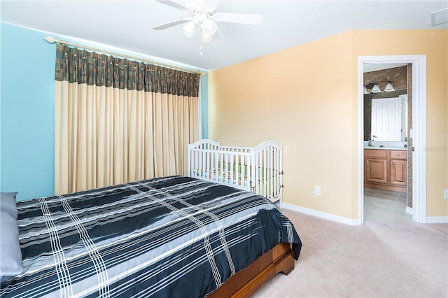 bedroom with ensuite bath and light colored carpet