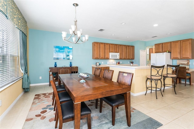 tiled dining space with a notable chandelier