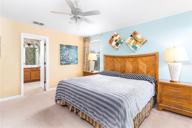 bedroom with light carpet, ceiling fan, and ensuite bathroom