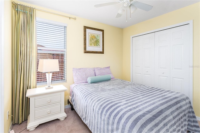 carpeted bedroom with ceiling fan and a closet