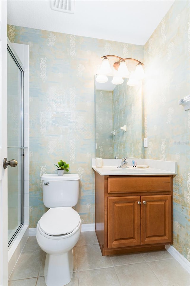 bathroom featuring a shower with door, vanity, tile patterned floors, and toilet