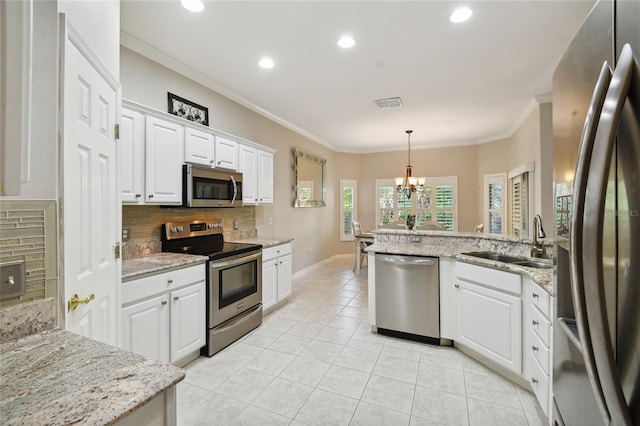 kitchen featuring appliances with stainless steel finishes, decorative light fixtures, light stone countertops, and white cabinets