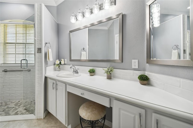 bathroom featuring vanity, tile patterned flooring, and a tile shower